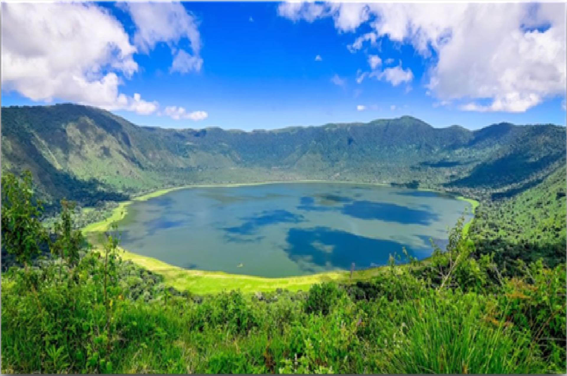 A crater lake surrounded by green highlands