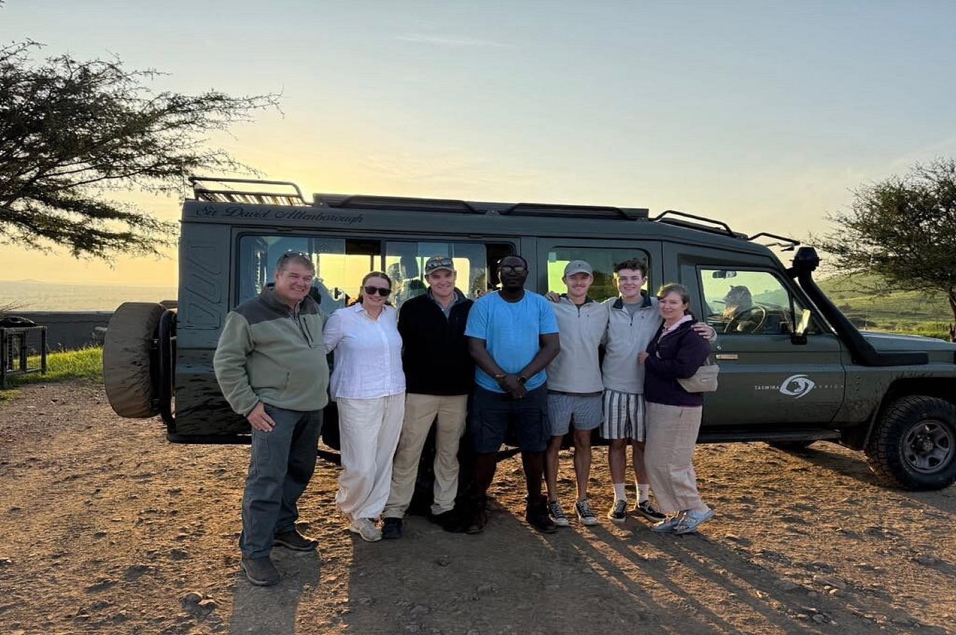 Taswira guests with their guide beside a safari vehicle